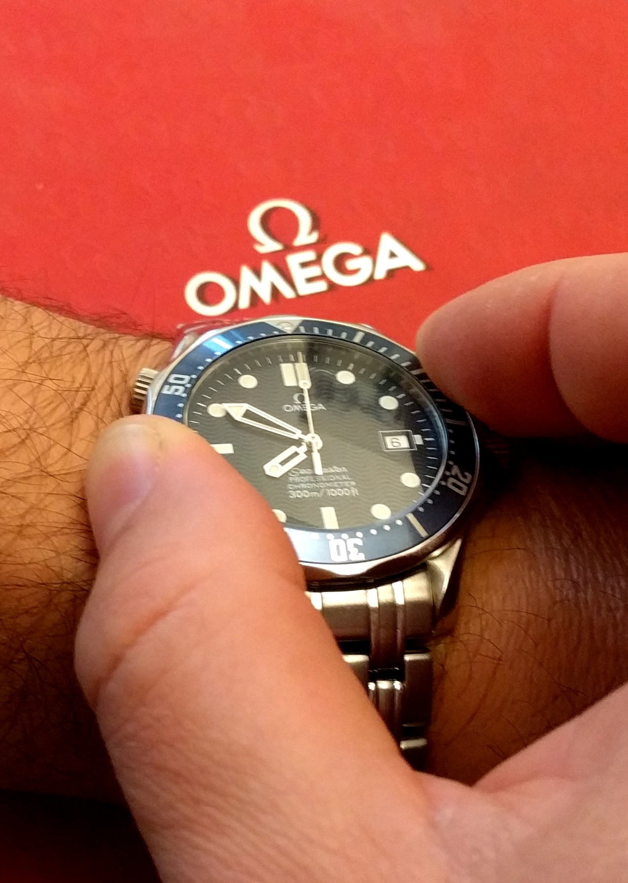 Photo de la manipulation de la lunette tournante d'une Omega Seamaster